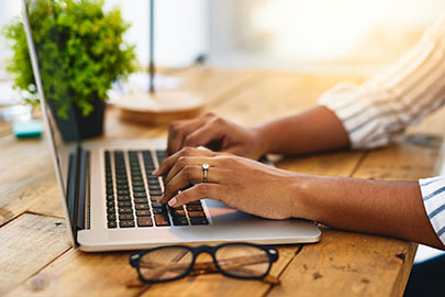 Woman's hands typing on laptop.