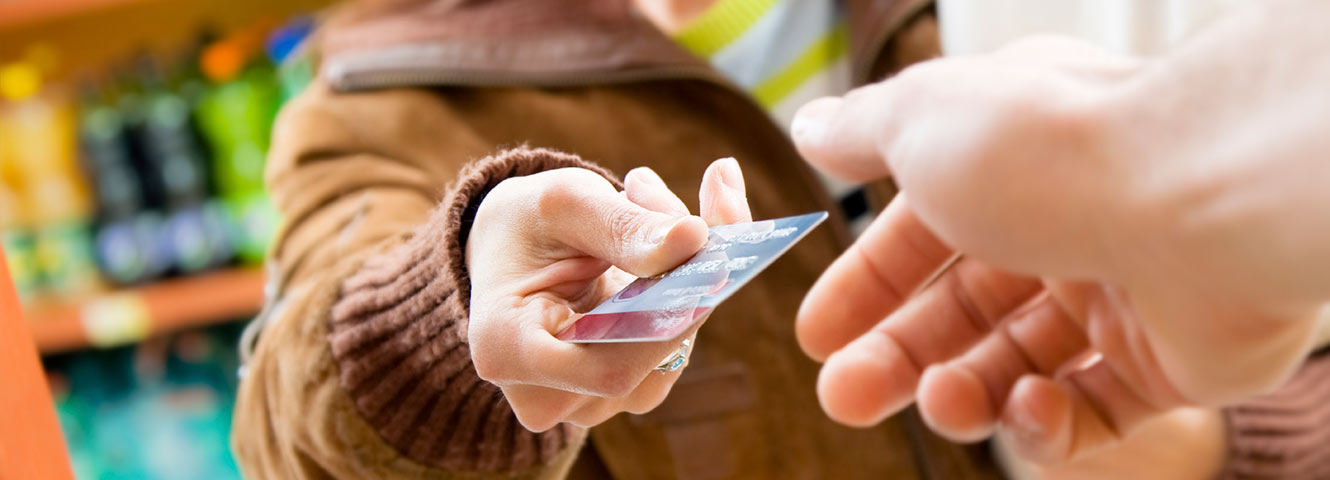 Woman handing over card to pay for groceries.