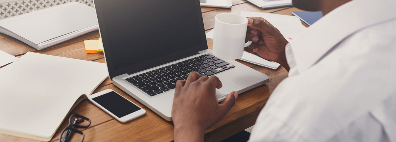 Man using laptop at desk.